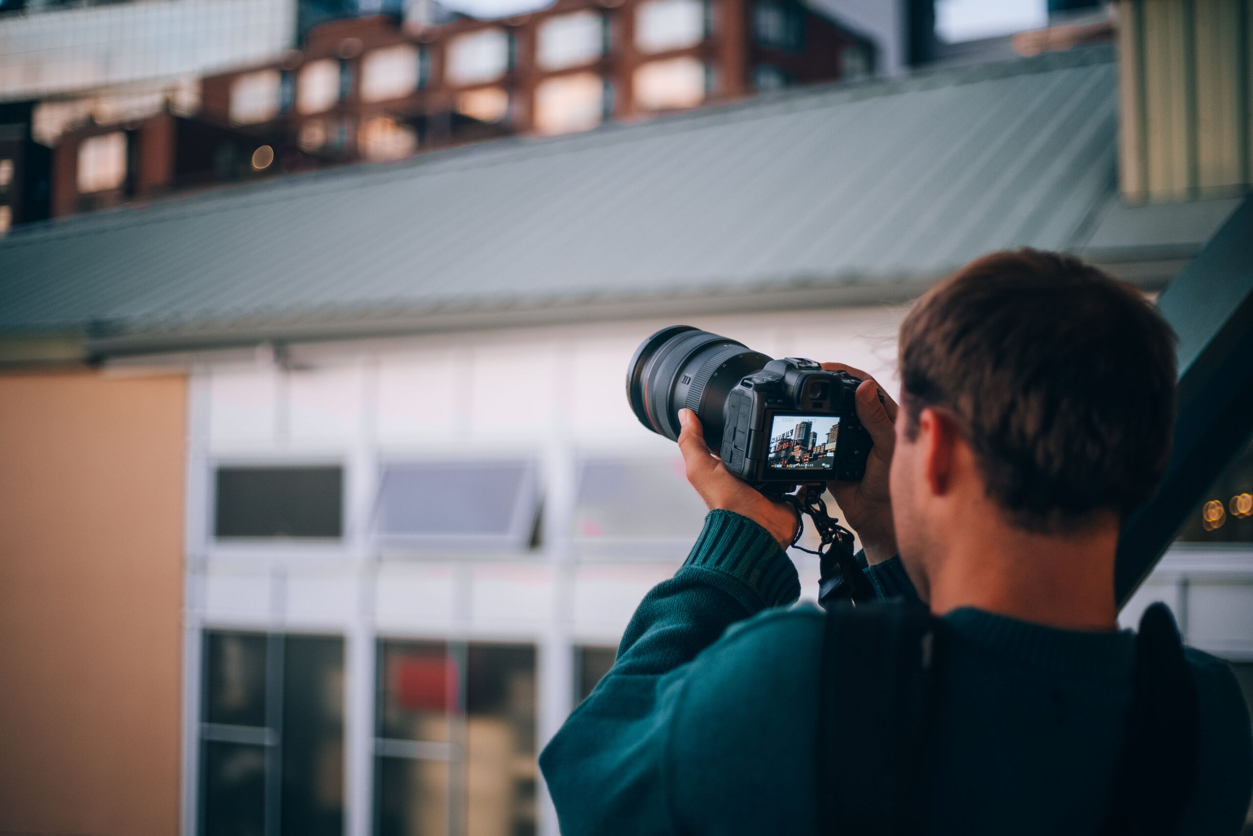 A photographer focuses on Seattle's architecture through a camera lens, highlighting the city's urban environment.