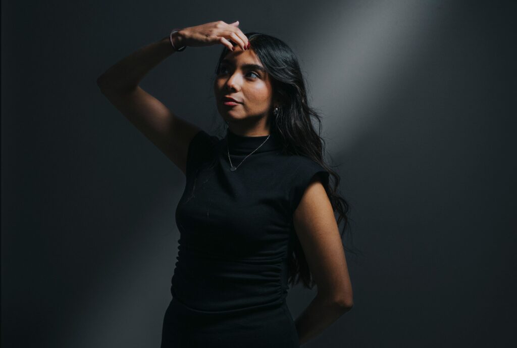 Artistic portrait of a woman in dramatic lighting, expressing introspection and mystery.