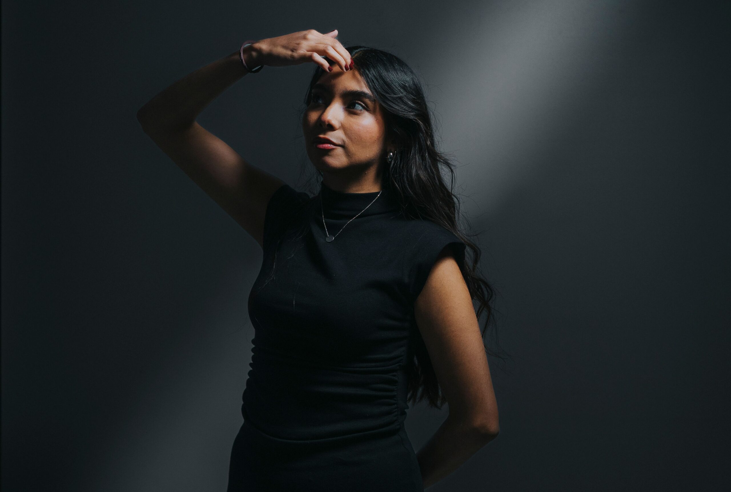 Artistic portrait of a woman in dramatic lighting, expressing introspection and mystery.